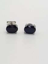 A pair of treated sapphire studs in silver.