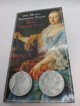A silver Maria Theresa taler with packaging