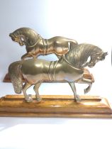 An attractive pair of old cast brass models of Welsh Cobb ponies mounted on oak stands as door stops