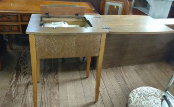 A sewing machine table. 83cm x 61cm x 47cm. Singer sewing machine included