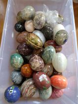 A box of polished stone eggs and painted eggs