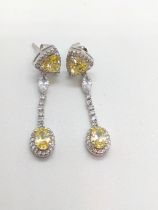 A pair of silver cubic zirconia-set articulated regency-style droplet earrings. Yellow and white