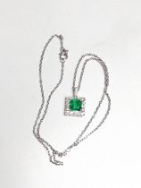 An 18ct white gold pendant set with octagonal cut emerald surrounded by Round Brilliant Cut