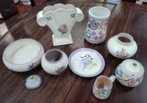 A collection of Poole Pottery including a vase, a plate, a lidded pot, a jar and others.