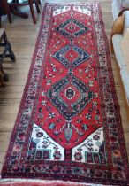 A rich red ground Persian Hamadan runner, full pile with medallion design. 300cm x 98cm.