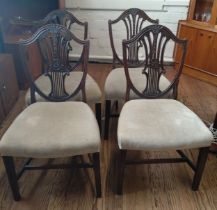 Four Hepplewhite style mahogany dining chairs with overstuffed seats.