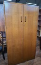 A large mid-century two-door wardrobe with hanging space, four shelves and a mirror attached