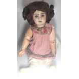 A Jumeau bisque head doll with glass eyes and jointed composition body, impressed 12 at rear of