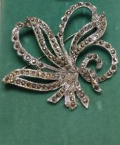 A white metal and marcasite ribbon twist brooch.