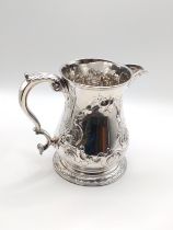 A George II silver floral embossed jug, hallmarked London 1754, 13oz, with later floral embossed