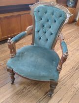 A green velour button-back parlour open arm chair on casters.
