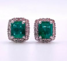 A pair of 18ct white gold, diamond, and emerald earrings set with emerald-cut emeralds of