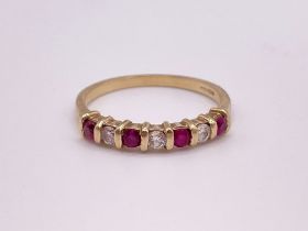 A 9ct yellow gold, diamond, and ruby ring, bar-set with three round brilliant-cut diamonds and