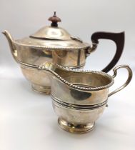 A silver teapot, hallmarked Birmingham 1932, makers mark indistinct, wooden handle and finial,