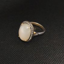 An oval cabochon moonstone and rose-cut diamond ring. Moonstone 7.95ct. Diamonds 0.37ct.