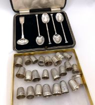A collection of twenty four silver thimbles, various designs, together with four silver spoons and a