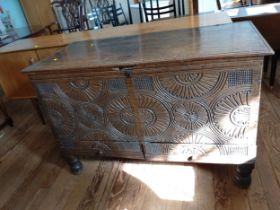 A 17th century oak chest, with later carved decoration, supported on short turned legs. 81cm x 124cm