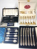 A collection of silver spoons and knives and Royal Albert gold-plated tea spoons.