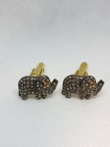 A pair of gold-plated silver elephant cufflinks set with rose-cut diamonds and ruby eyes. Diamonds