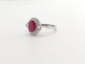 An 18ct white gold oval ruby and Round Brilliant Cut and baguette diamond cluster ring. Ruby 1.26ct.