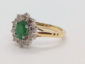An oval emerald and diamond cluster ring set in 9ct white and yellow gold. Emerald 0.85ct.
