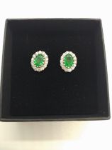 An 18ct white gold oval emerald and Round Brillaint Cut diamond cluster ear studs, boxed. Emeralds