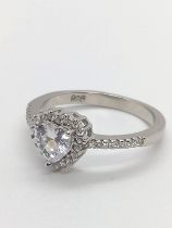 A silver ring set with a central white heart-shaped cubic zirconia, with a halo of CZs and CZ