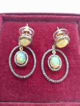 A pair of silver-gilt chandelier style articulated drop earrings each set with two cabochon opals