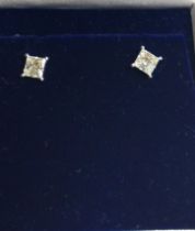 A pair of 18ct white gold princess-cut diamond solitaire studs,boxed. Diamonds 1.06ct. Certificate