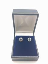 A pair of 18ct white gold oval-cut sapphire and round cut diamond halo ear studs, boxed. Sapphires