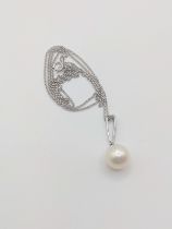 A 9ct white gold cultured pearl and diamond pendant, the round pearl beneath diamond-set baton