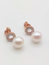 A pair of 9ct rose gold suspended cultured pearl and diamond halo droplet earrings, the round cut