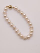 An off-white cultured pearl bracelet with 9ct yellow gold ball clasp, 18cm