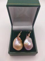 A pair of 18ct rose gold mounted peach coloured baroque pearl and diamond drop earrings, the round