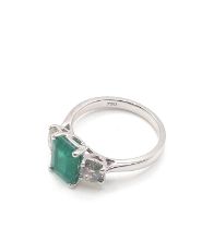 A certificated 18ct white gold emerald and diamond trilogy ring. Octagonal step-cut emerald 1.