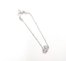 A silver bracelet with white cubic zirconia-set dolly charm and spectacle-set white cubic zirconia.