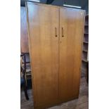 A large mid-century two-door wardrobe with hanging space, four shelves and a mirror attached