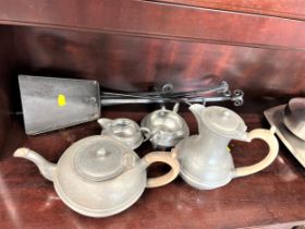 A four piece pewter tea set and some fire irons.