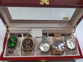 A collection of five fashion watches in a wooden presentation case.