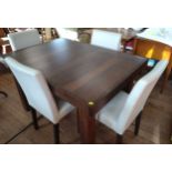 An extending dark wood dining table (75cm x 125cm x 90cm) and four cream chairs.