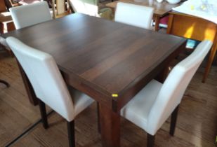An extending dark wood dining table (75cm x 125cm x 90cm) and four cream chairs.