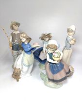 Lladro boy with fishing rod and two girl figures, 17cm to 23cm, and two Nao girl figures, 18cm and