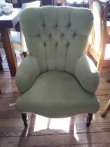 A green button-back occasional chair