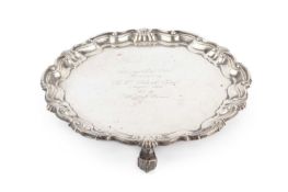 A George V silver small salver, with shaped scallop and scroll border, on scroll feet, engraved