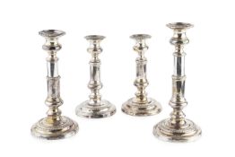 A set of four silver plated candlesticks, with gadrooned borders and telescopic columns, on circular