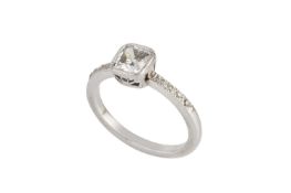 A diamond single stone ring, the cushion-shaped brilliant-cut diamond in millegrain collet