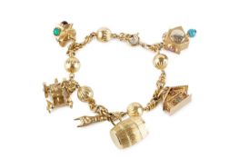 A charm bracelet, the fancy-link bracelet with fluted hollow bead spacers, stamped '750', suspending