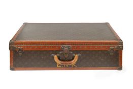 A Louis Vuitton suitcase, with studded leather bound borders and gilt printed logo decoration, label