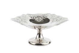 A silver hexagonal tazza, the shaped borders pierce-decorated with scrolling foliage, on circular
