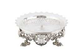 An early 19th century silver plated circular stand, the border cast and pierced with scrolling